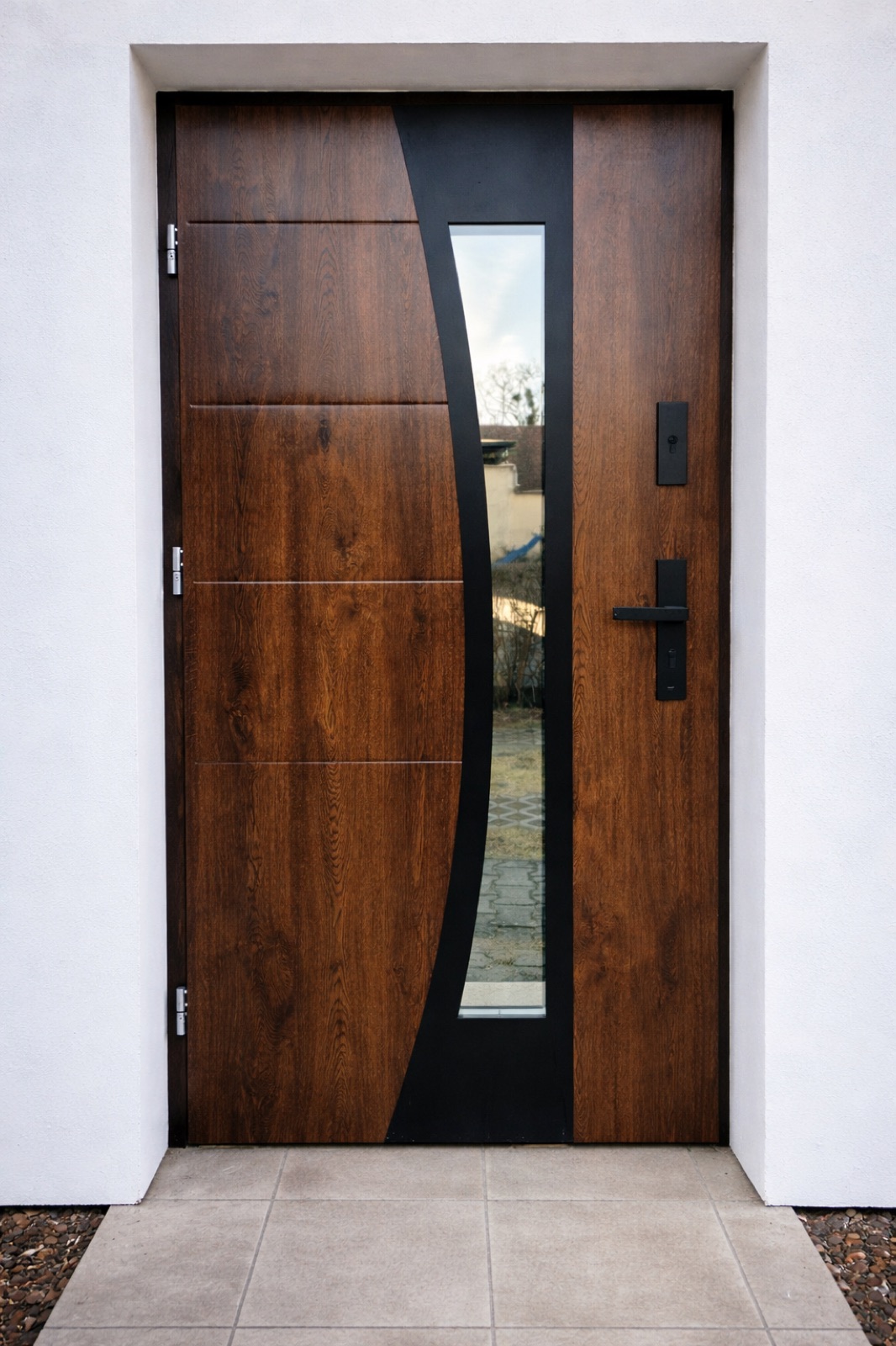 A timber entrance door with a curved glazed feature panel